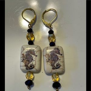 Earrings Of A Seahorse Purple On A Beige Stone...